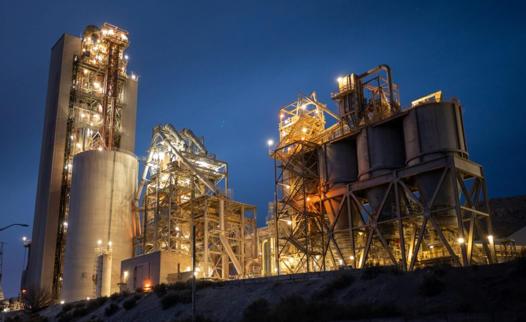 Night view of an illuminated cement plant in Monolith, California, stunning industrial architecture.