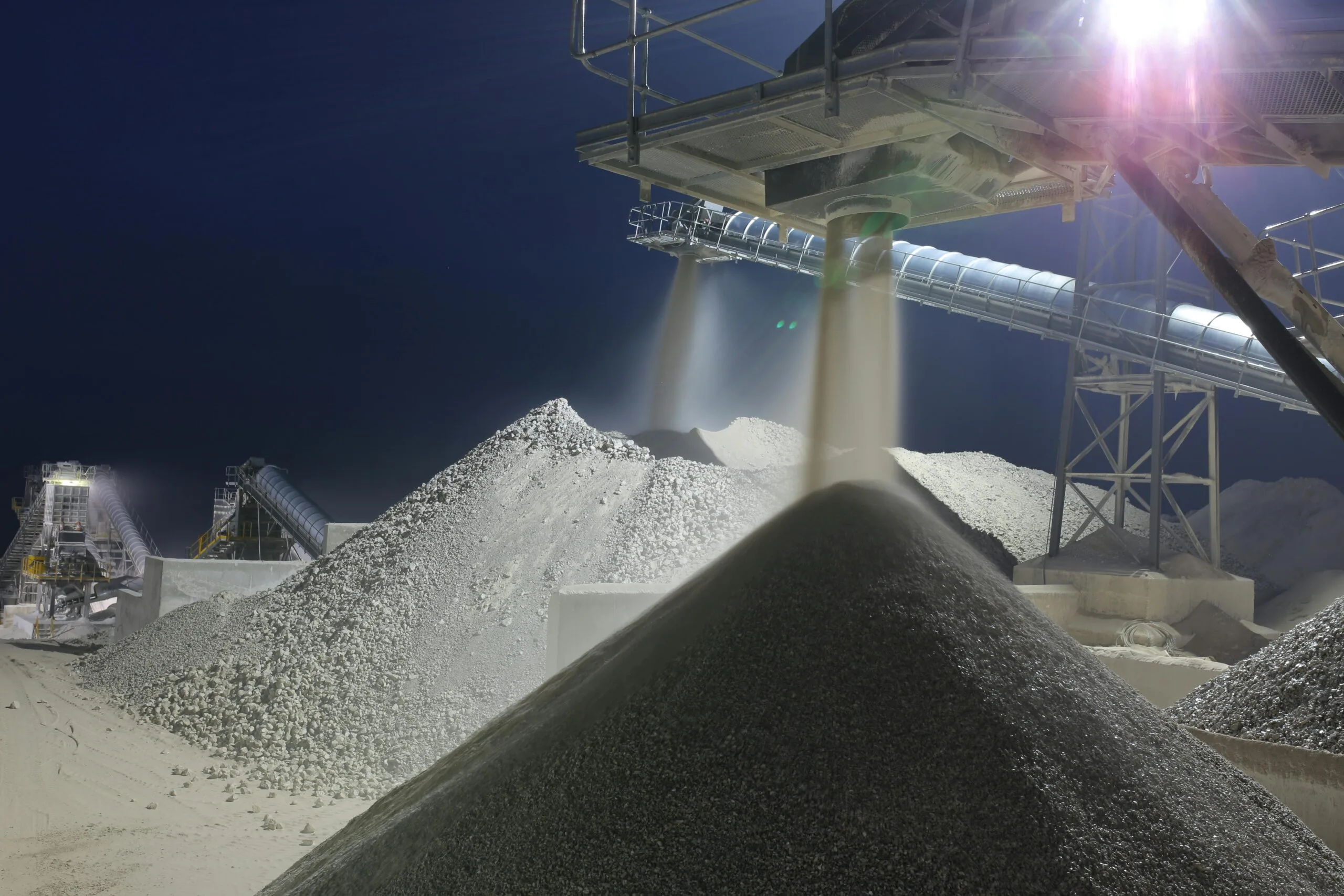 Nighttime industrial sand processing site in Ankara, Turkey with machinery and heaps of sand.